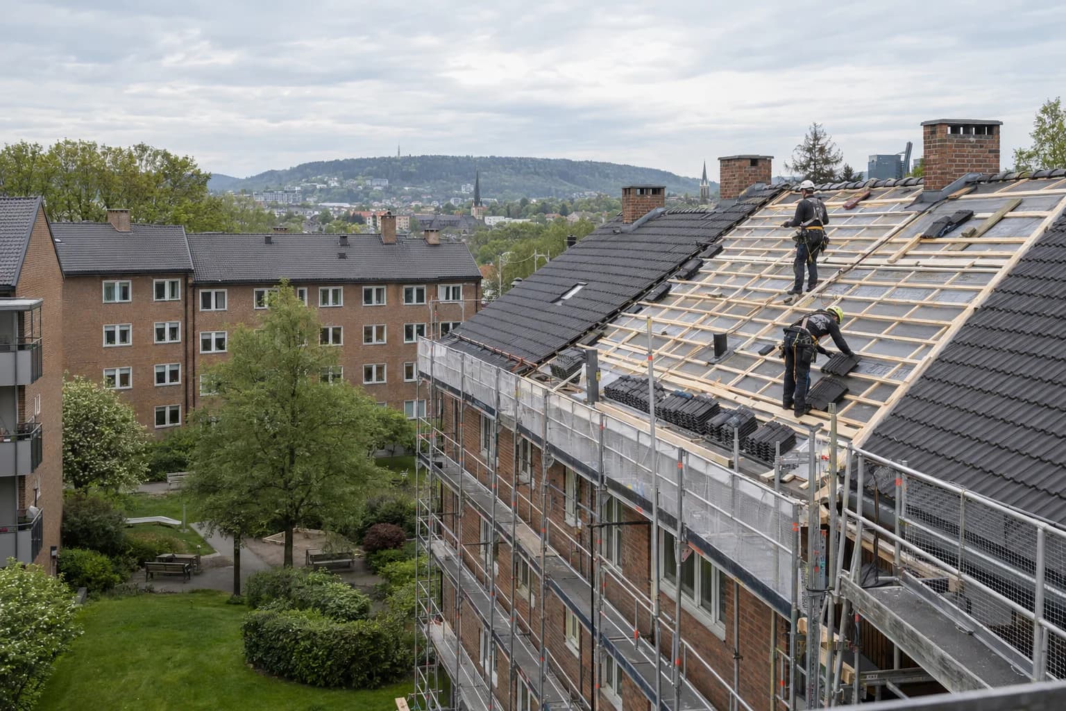 Takbytte på en boligblokk i Oslo med stillas, synlig undertak og taktekkere i arbeid